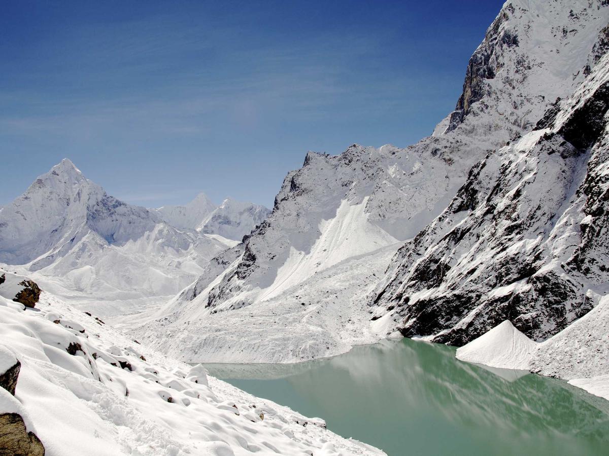 Snowy peaks around a glacial lake