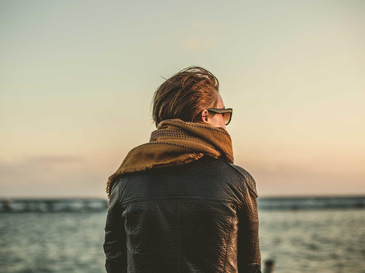 A guest in a scarf looking out over the water