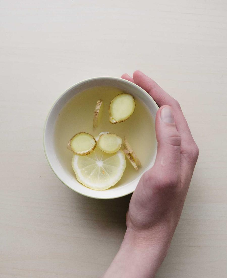 Hands holding a cup of lemon tea