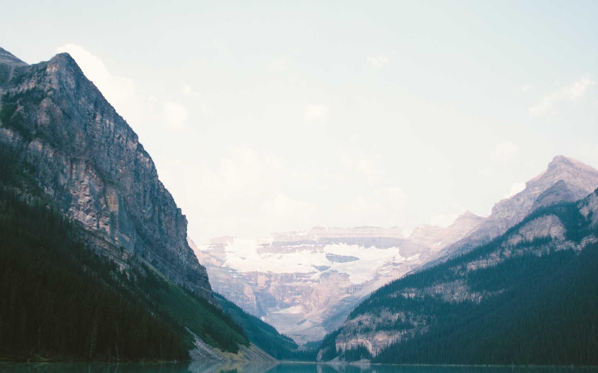 A turquoise lake below steep spring mountains