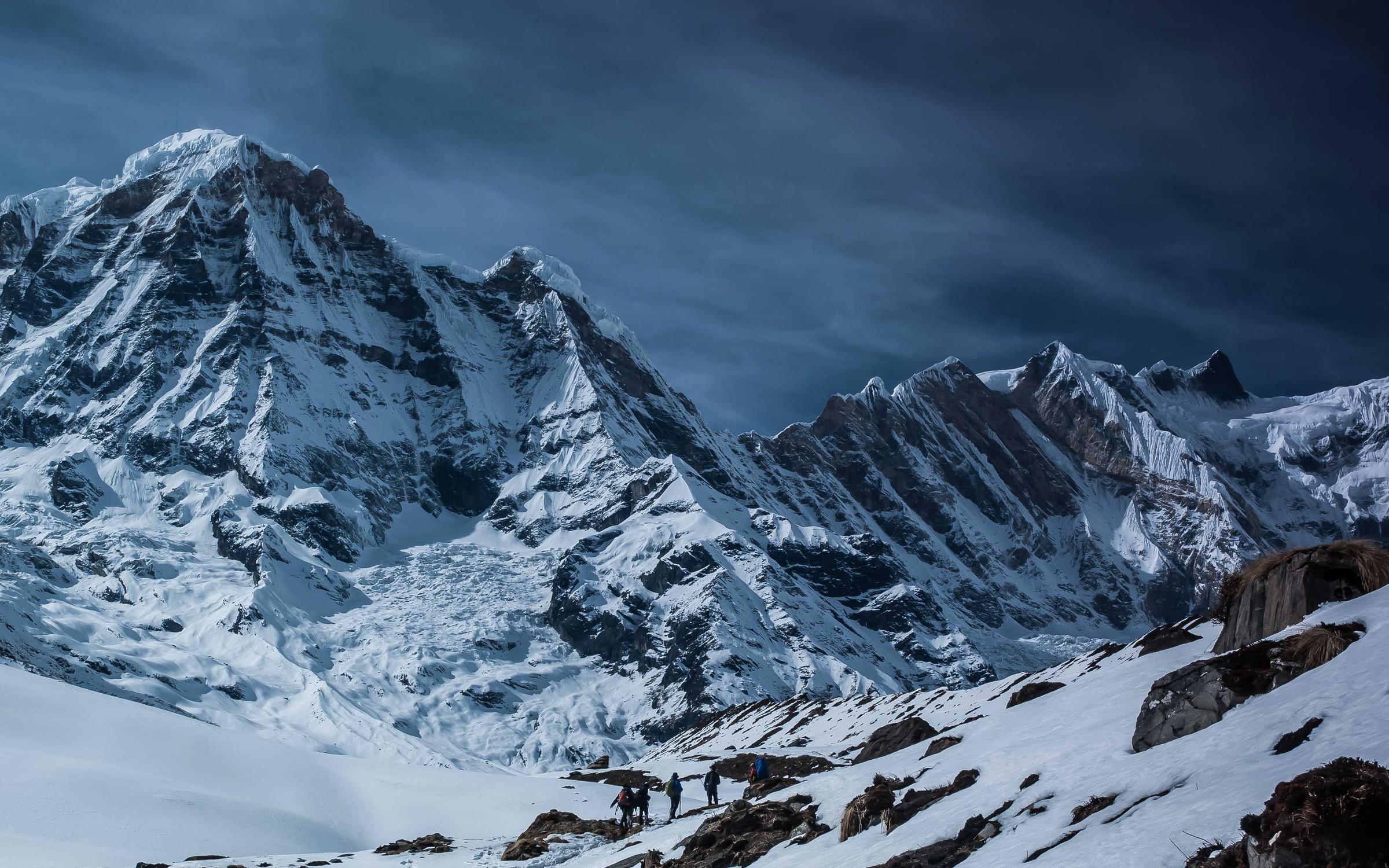 Snow-covered peaks under a dark winter sky